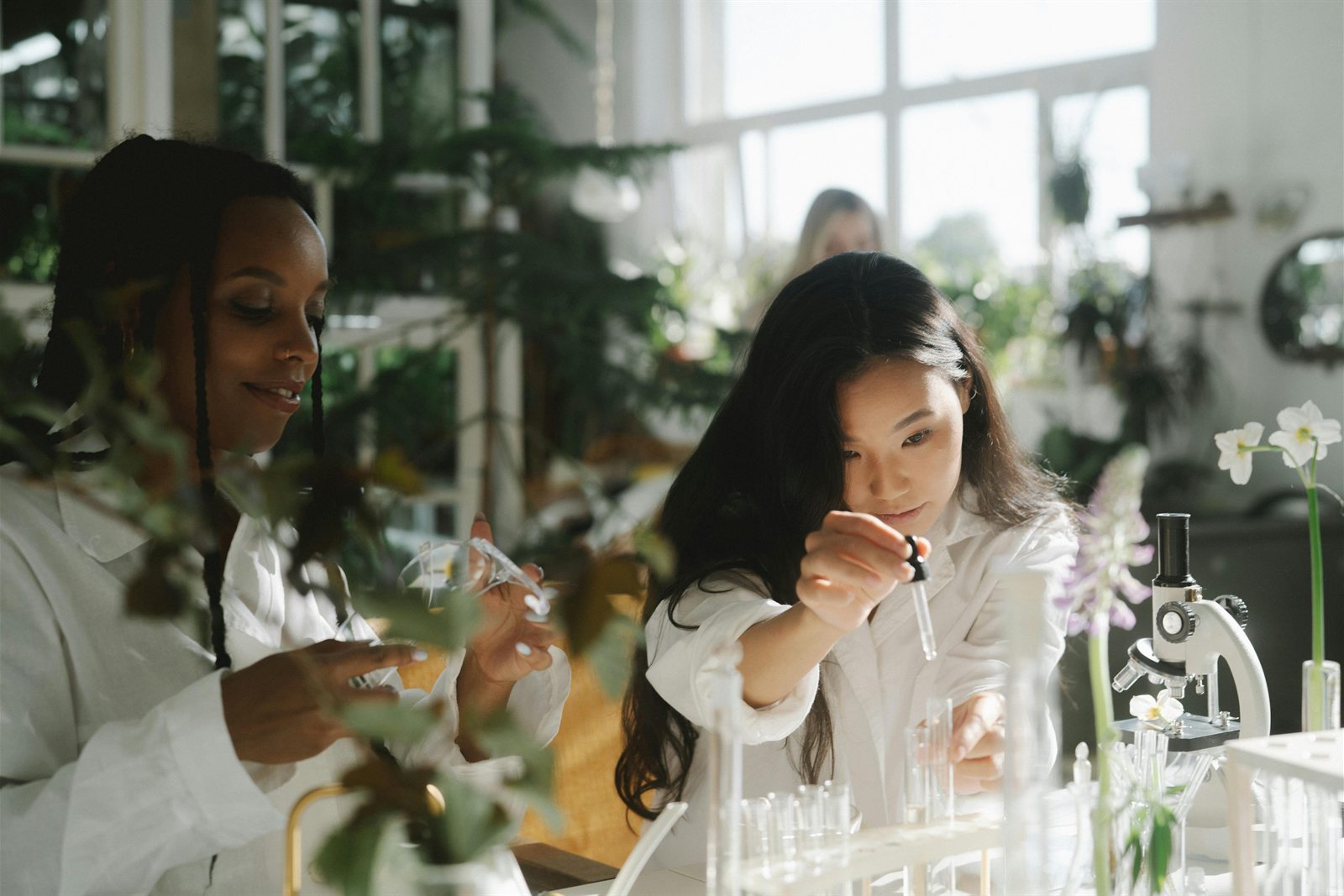 Two researchers working in a plant-filled laboratory